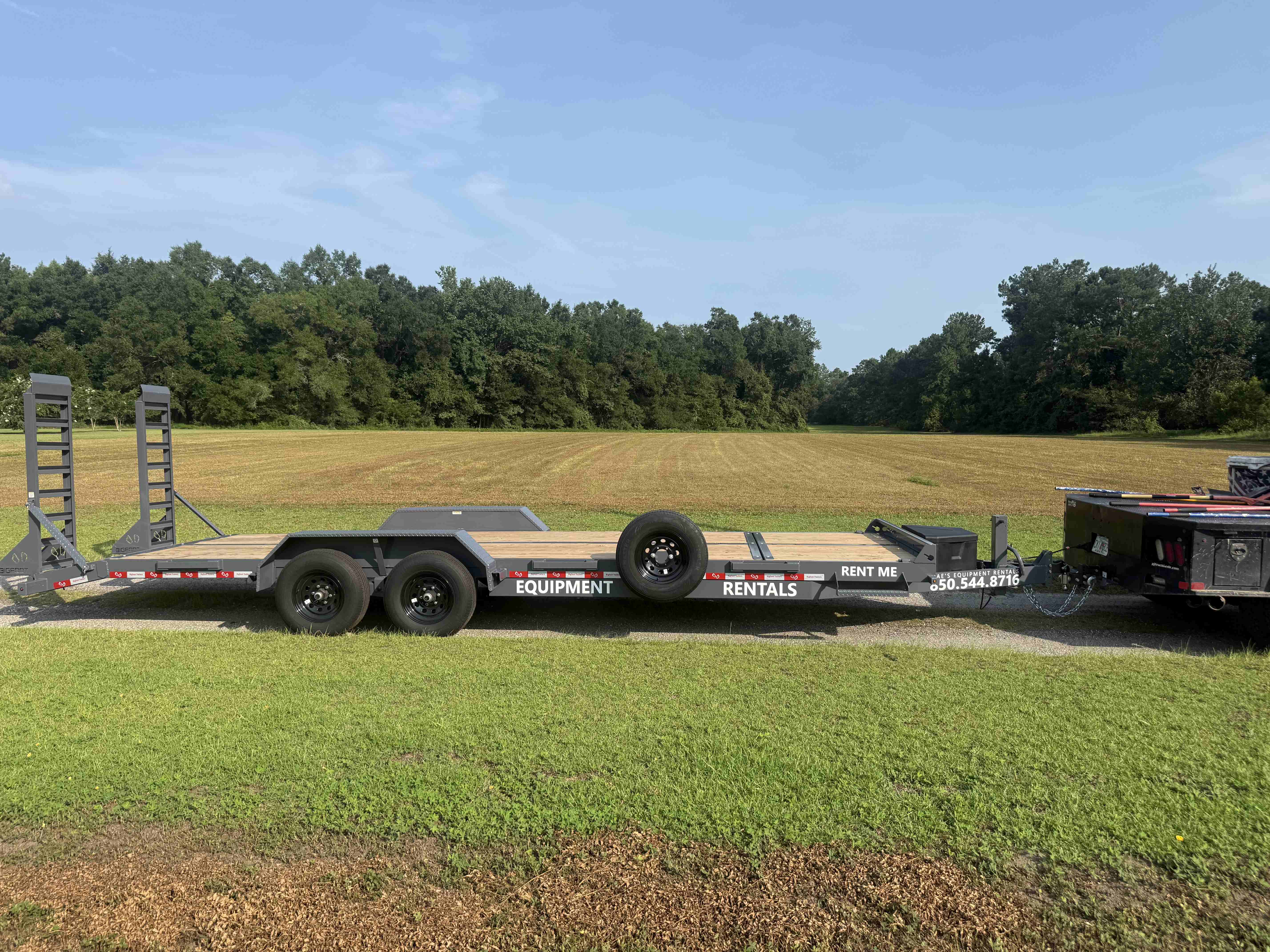 Mae's Equipment Rentals branded equipment trailer parked in an open field, ready for rent